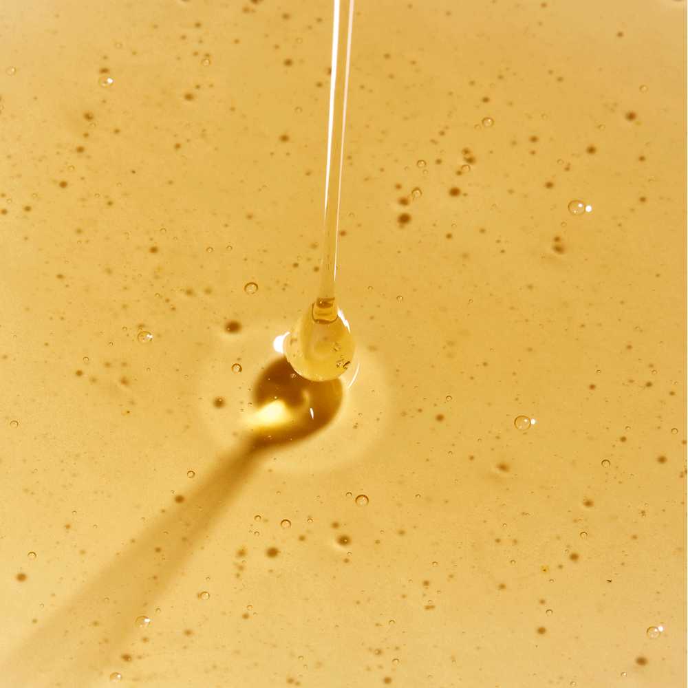 gif of rahua classic shampoo being poured out onto a puddle of classic shampoo on a flat surface to show texture of product shampoo is golden and somewhat thick|variant:074-oz